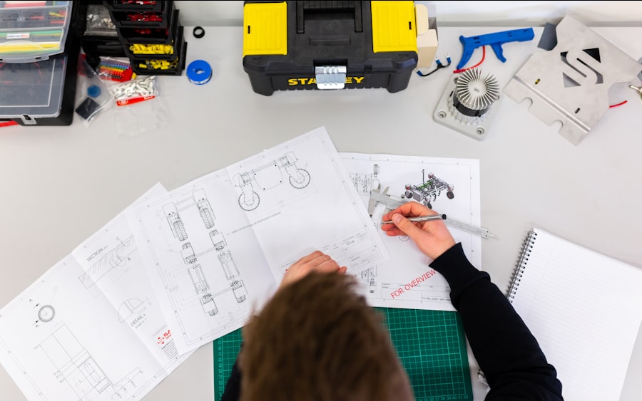 An engineer annotating technical drawings at a workbench.